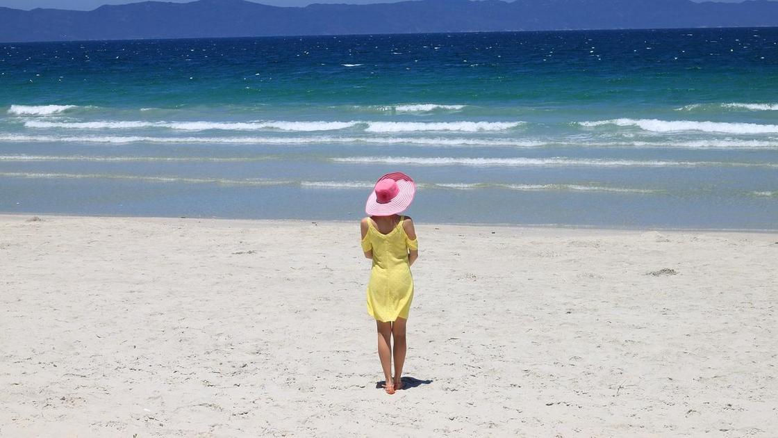 Девушка в шляпе смотрит на море
