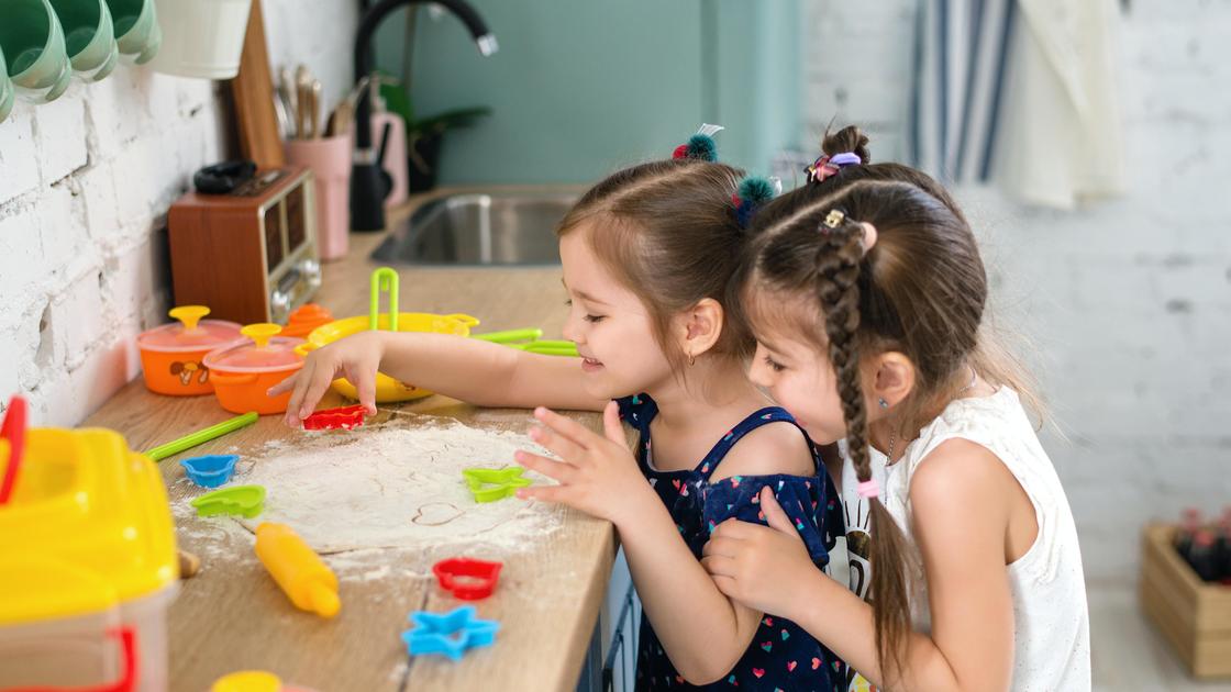 Девочки играют с игрушечной посудой