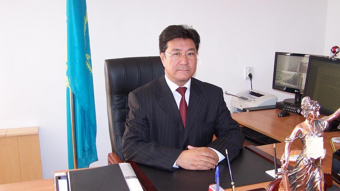 Абай Дауренбеков сидит за рабочим столом