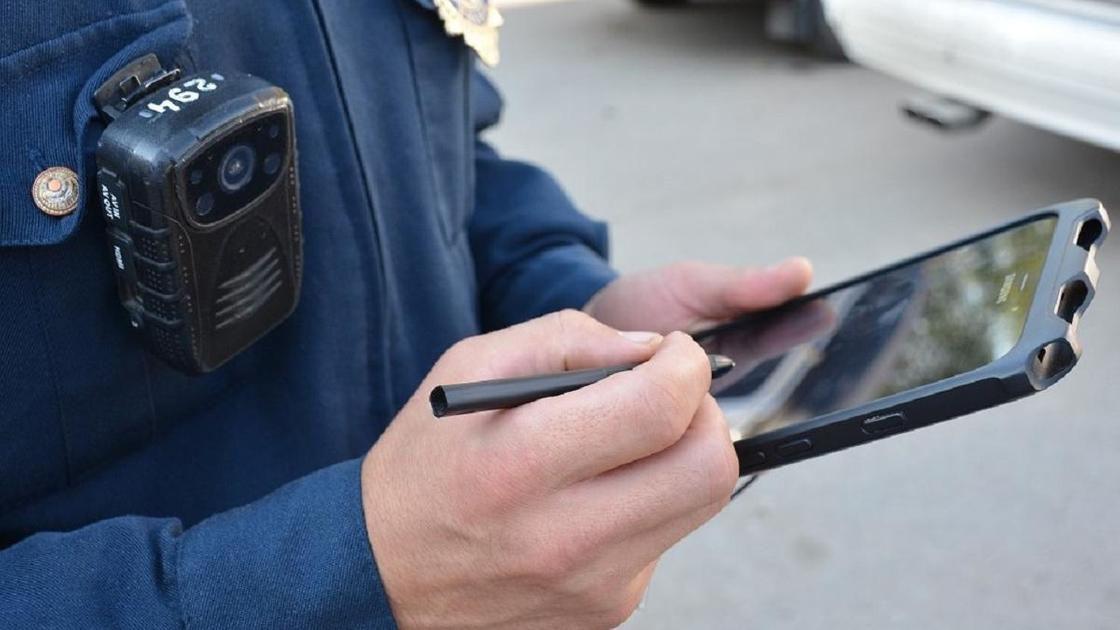 Полицейский держит в руках планшет