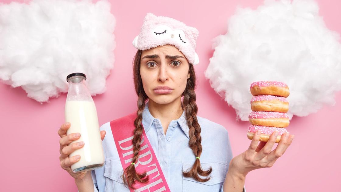 Девушка держит молоко и пончики