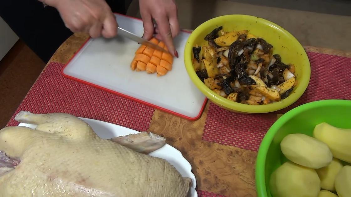 Морковь нарезают на разделочной доске для добавления в начинку