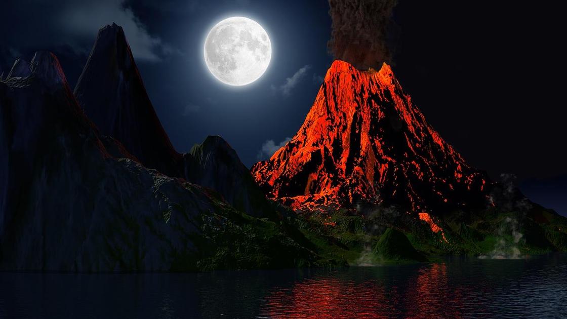 Извергающийся вулкан на фоне полной Луны