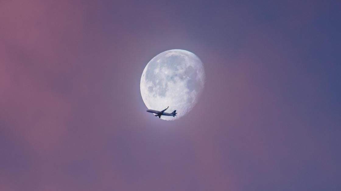 самолет на фоне луны