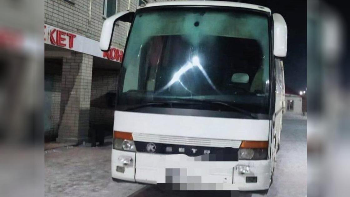 Белый автобус стоит у здания зимой