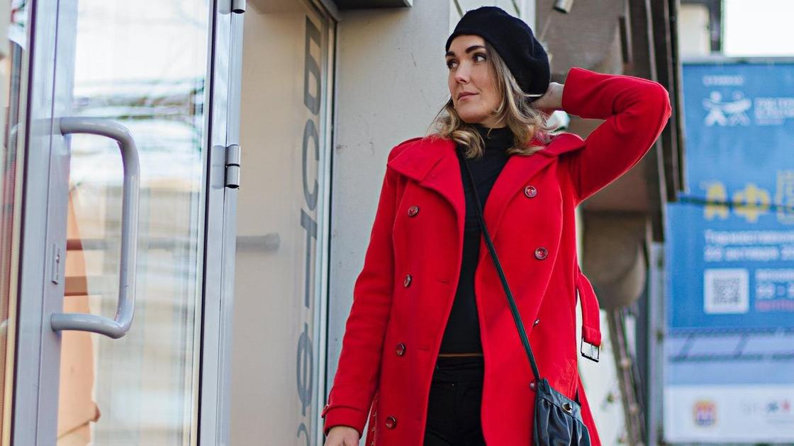 Женщина в красном пальто идет по улице