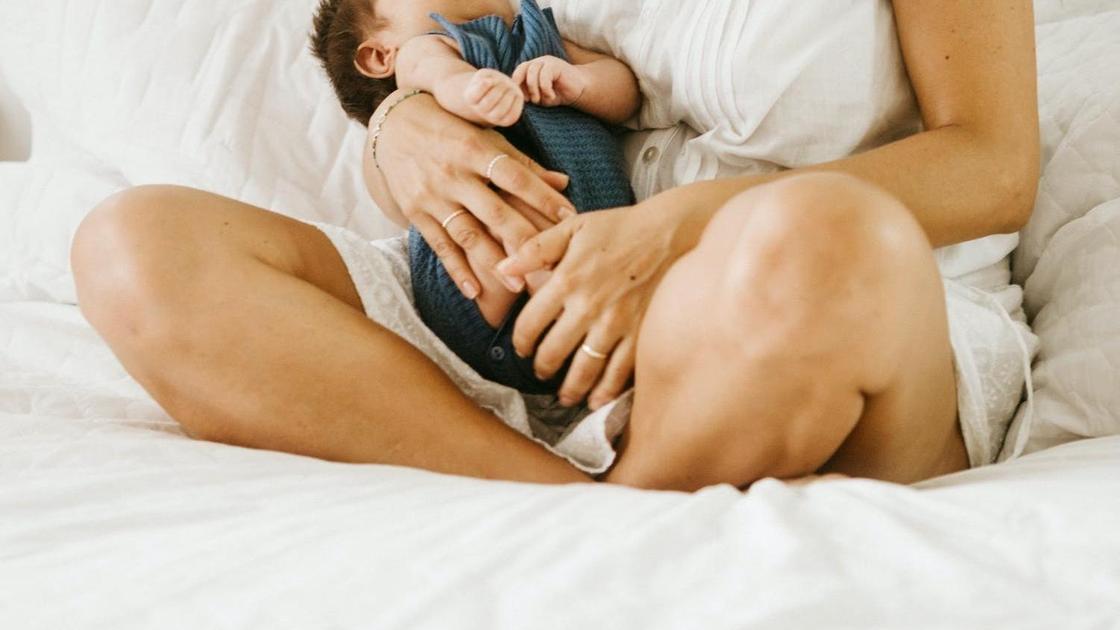 Женщина держит младенца на руках