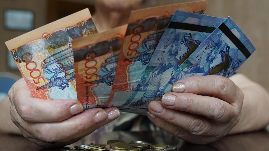 Пожилая женщина держит деньги в руках