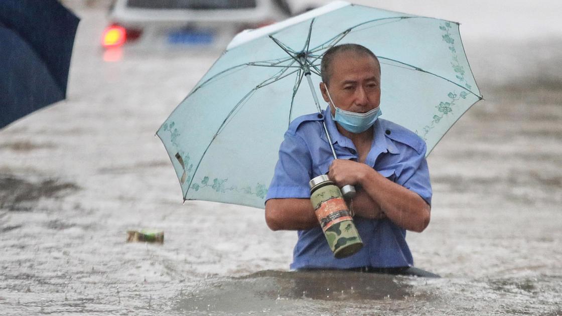 Мужчина под зонтом в воде