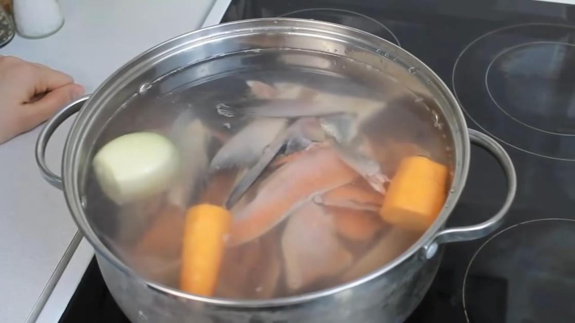 В кастрюле с водой вымытая морковь, лук и рыбный набор