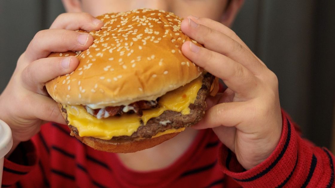 Ребенок ест бургер
