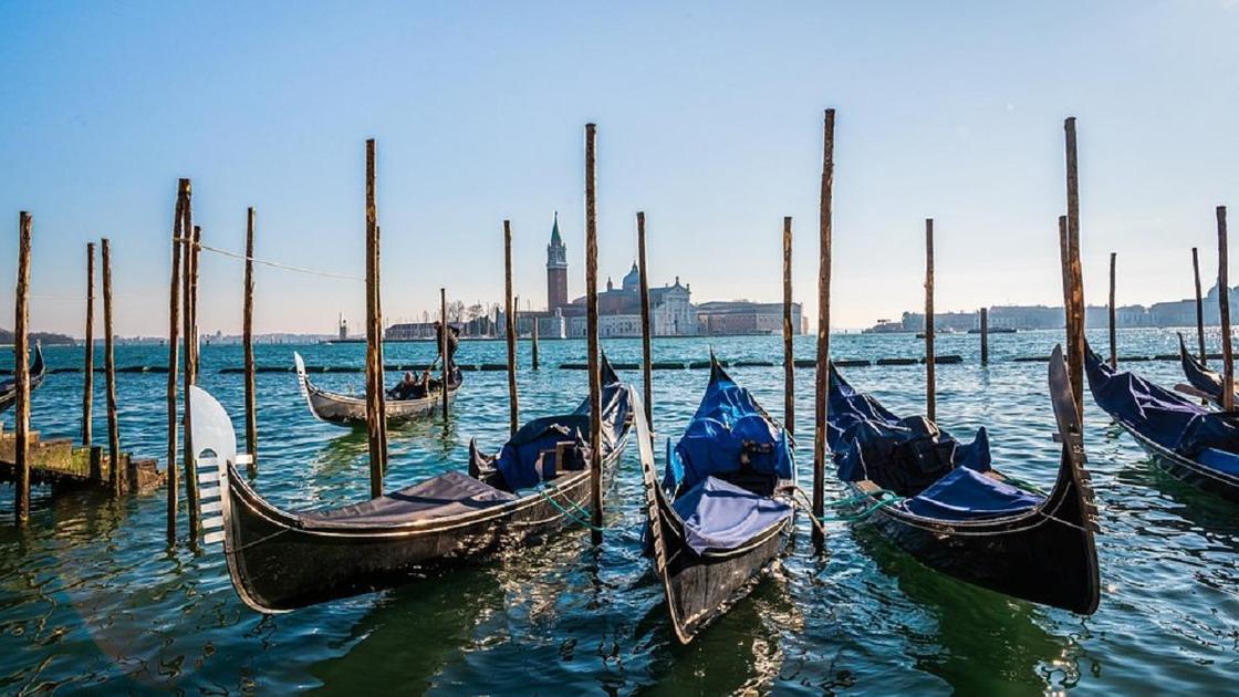 Гондолы стоят на воде в Венеции