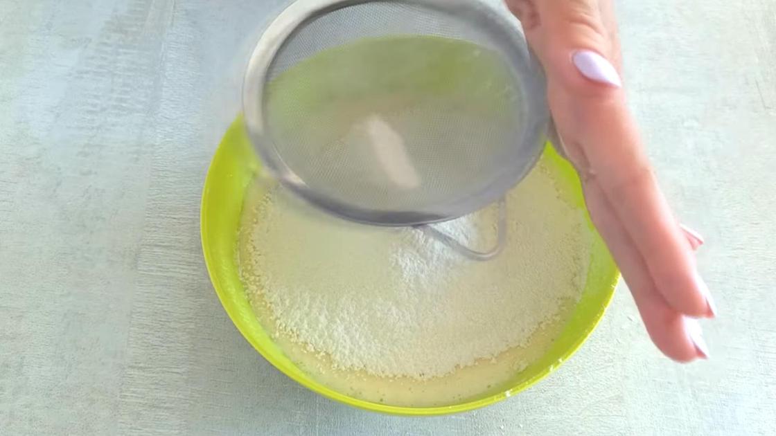 Муку просеивают в миску с жидкой основой через сито