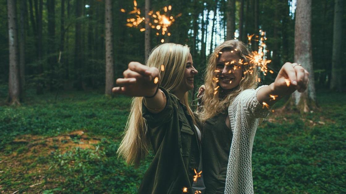 девушки с бингальскими огнями в руках на фоне леса