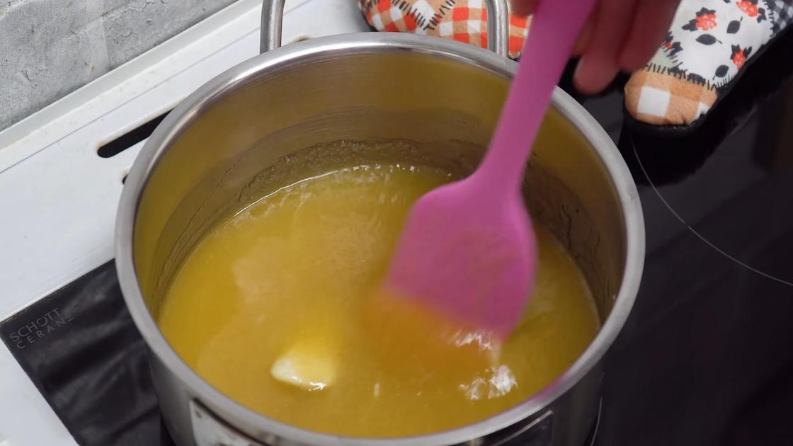 В кастрюле перемешивают силиконовой лопаткой растопленный мед с маслом