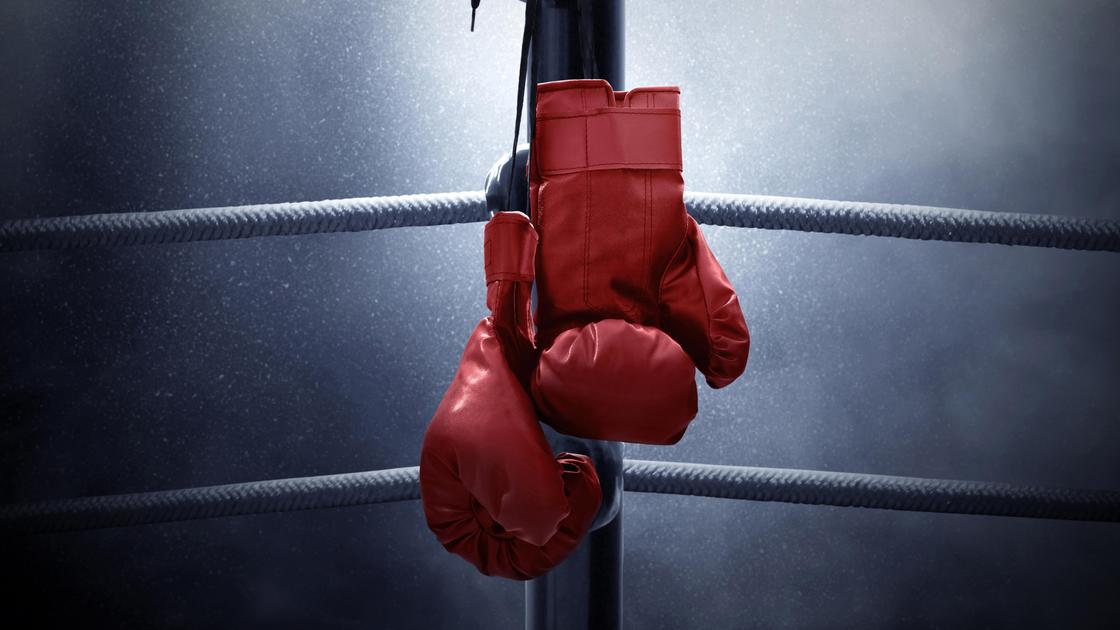 Боксерские перчатки висят в углу ринга