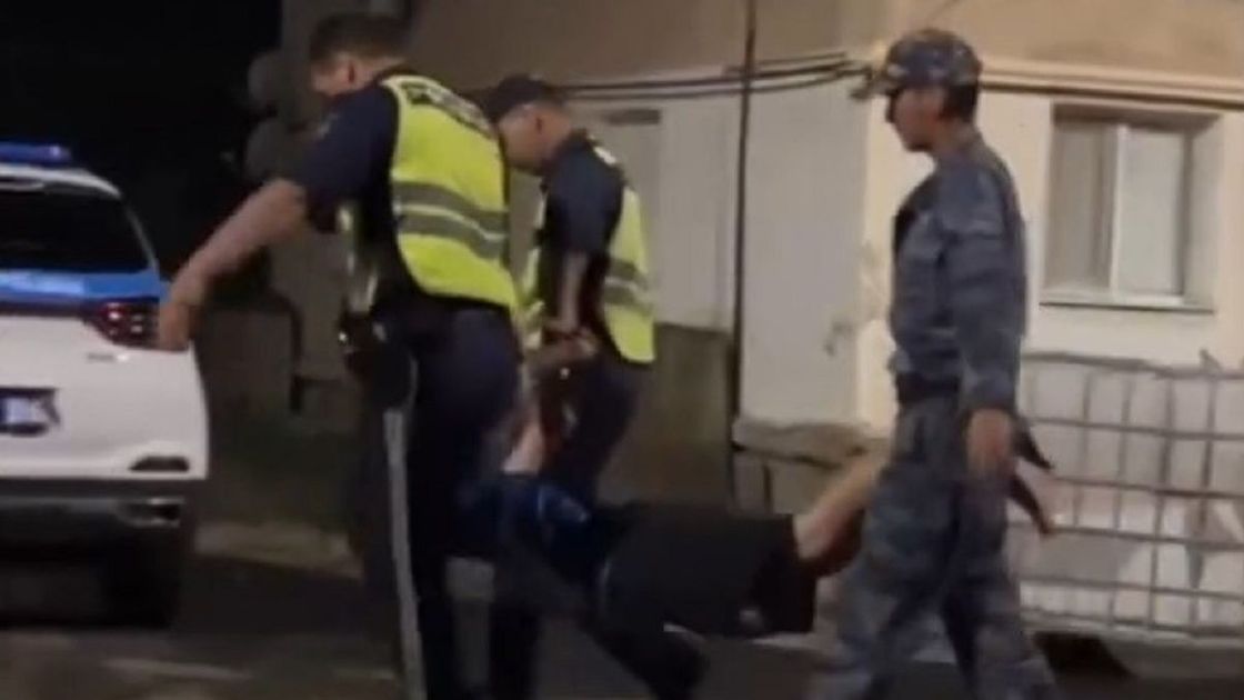 Полицейские несут мужчину в Атырау