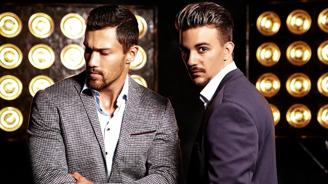 Мужчины-модели позируют на фоне софитов