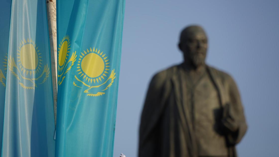 Флаги Казахстана, а за ним памятник
