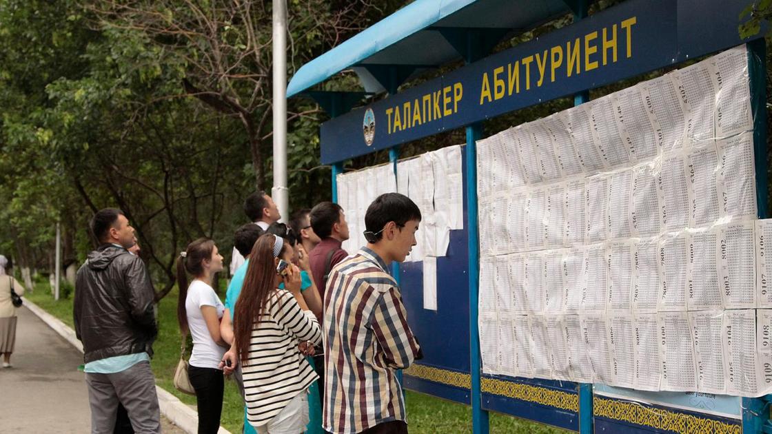 Казахстанские студенты смотрят на доску объявлений в вузе