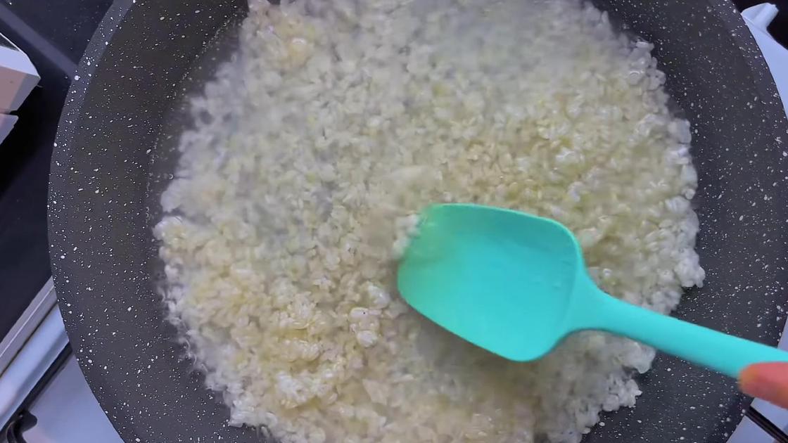 В сковороде лопаткой перемешивают рис с водой