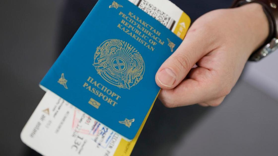 Человек держит казахстанский паспорт