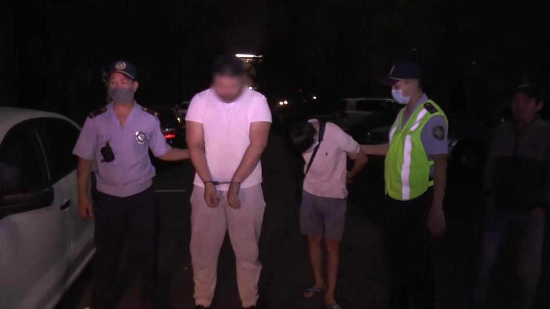 Полицейские стоят с задержанными мужчинами