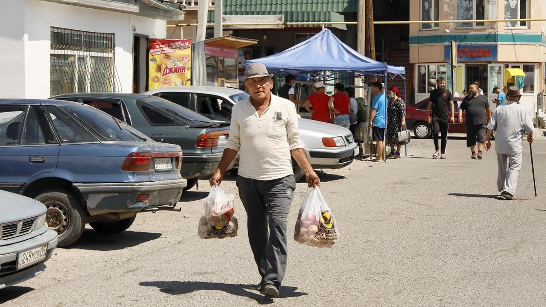 Мужчина идет с рынка в Жаркенте