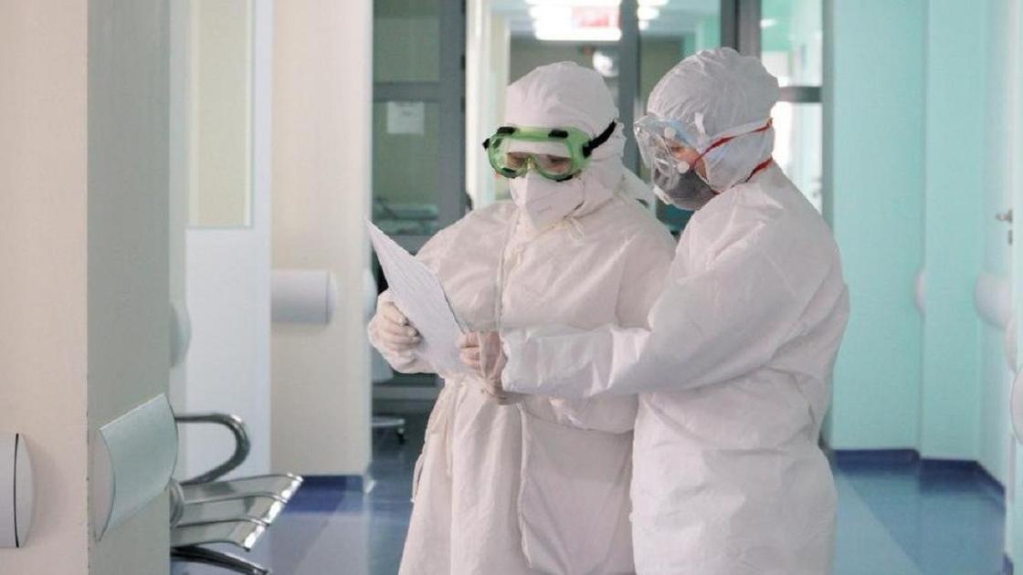 Врачи в СИЗах стоят в коридоре больницы