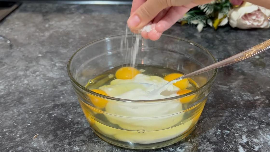 В миску со сметаной и яйцами добавляют соль