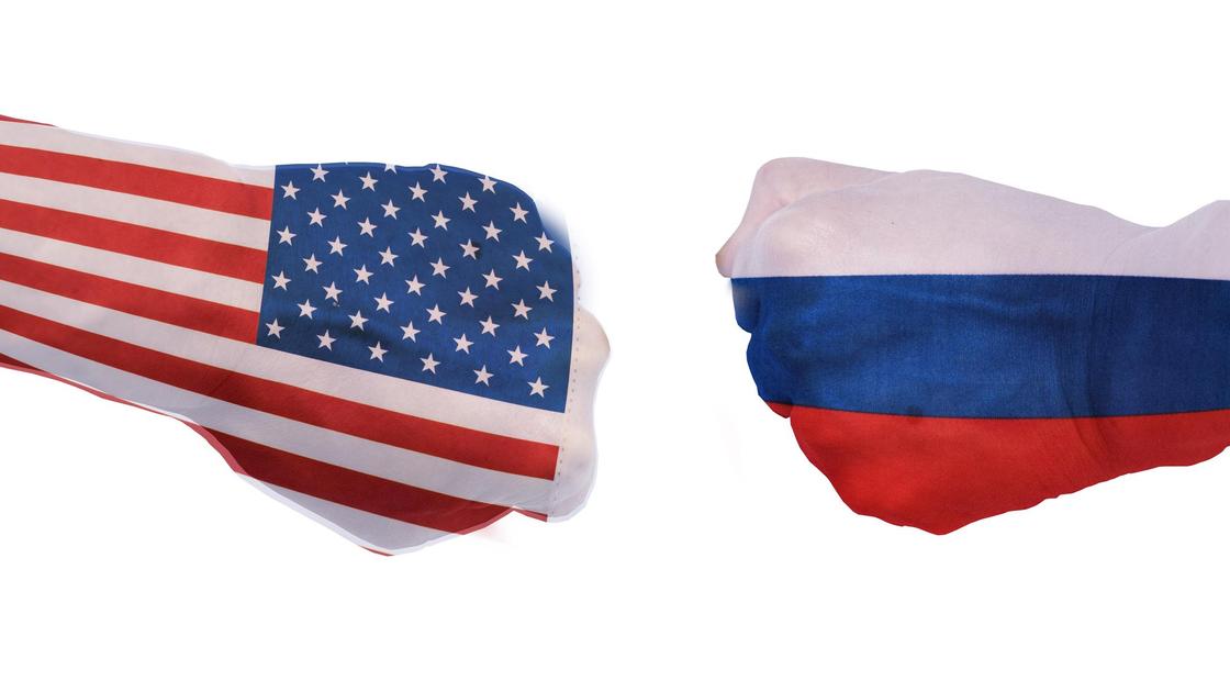 Руки с флагами США и России