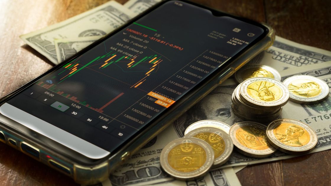 Смартфон с графиком лежит на долларах