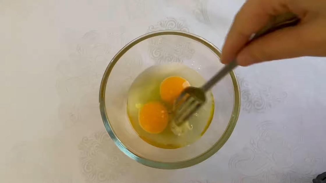 В пиале смешивают куриные яйца