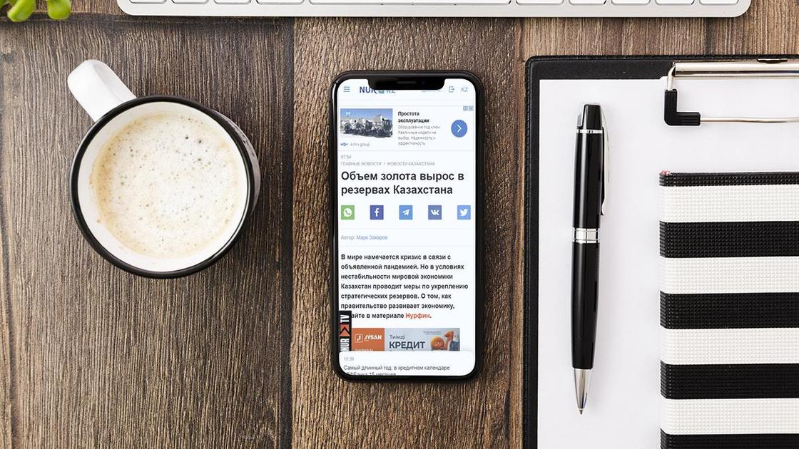 Мобильный телефон, чашка кофе и планшет на столе