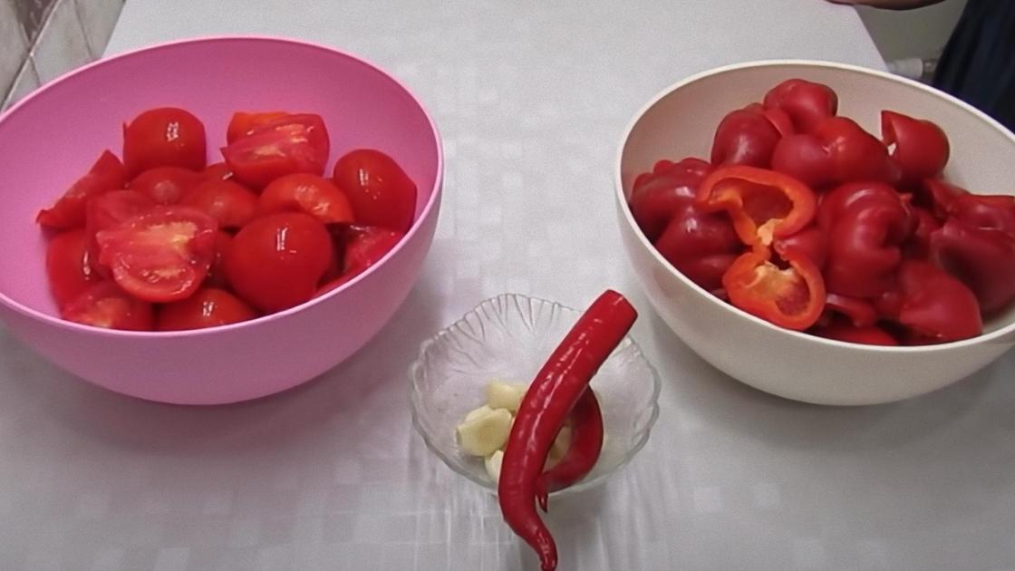 В мисках нарезанные помидоры и сладкий красный перец, в креманке дольки чеснока, перец чили