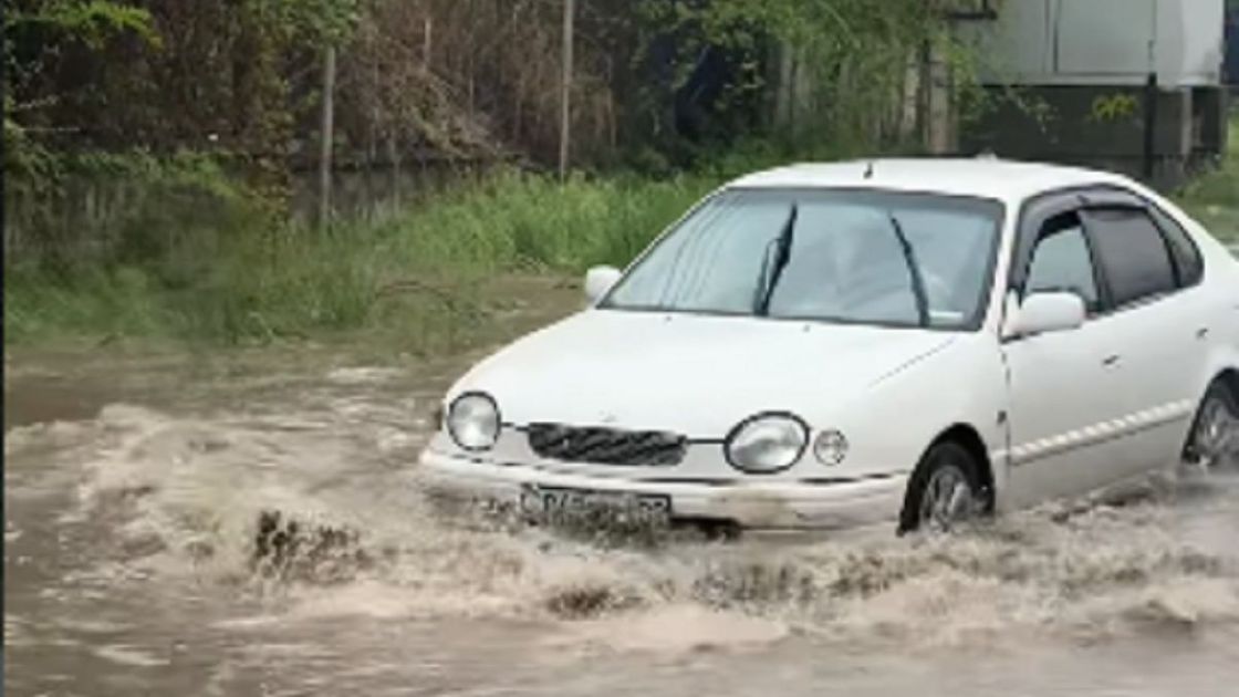 Машина едет по подтопленной улице