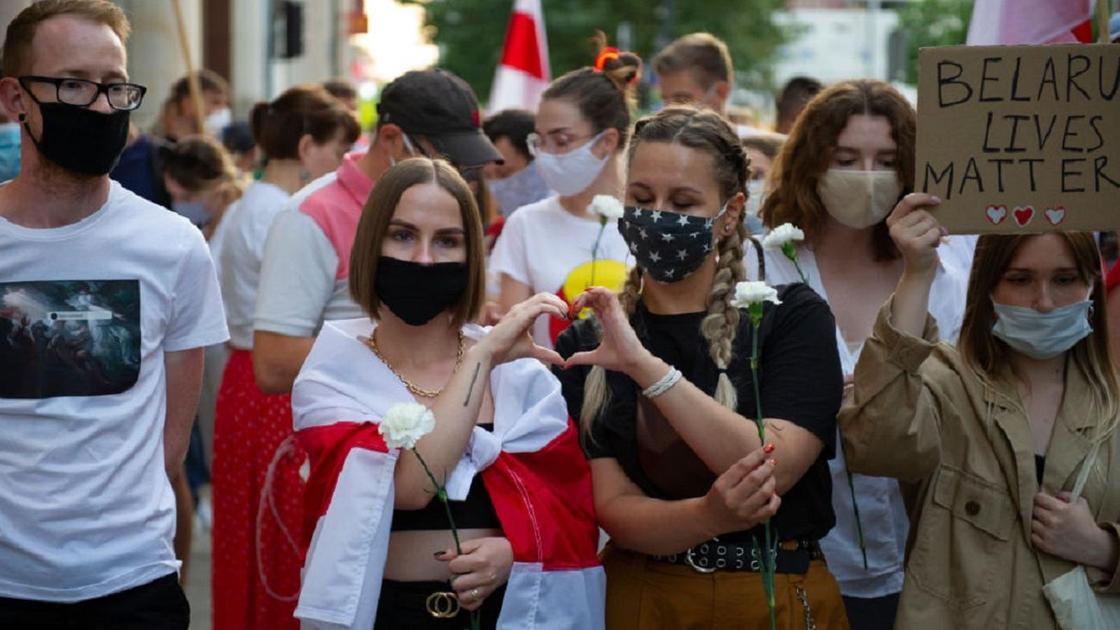 Девушки показывают сердечко в толпе протестующих в Беларуси