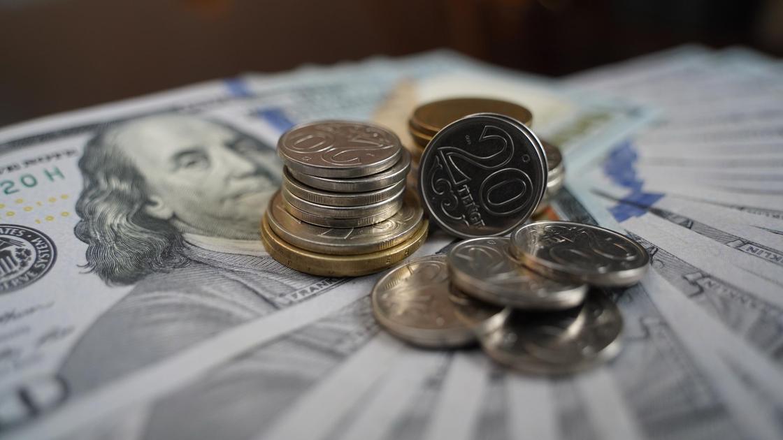 Долларовые купюры и монеты на столе