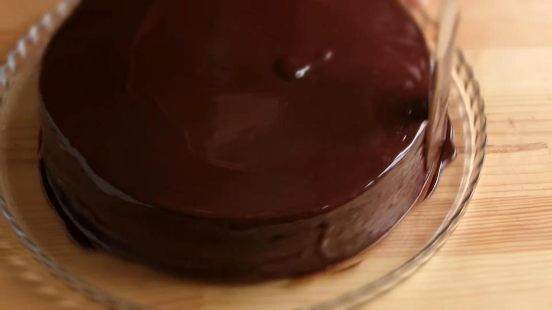 Торт на сервировочном блюде выравнивают шоколадной глазурью