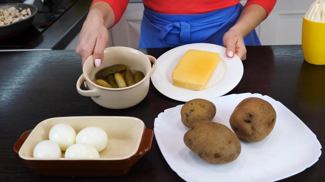 На столе вареный картофель, яйца, огурцы и сыр