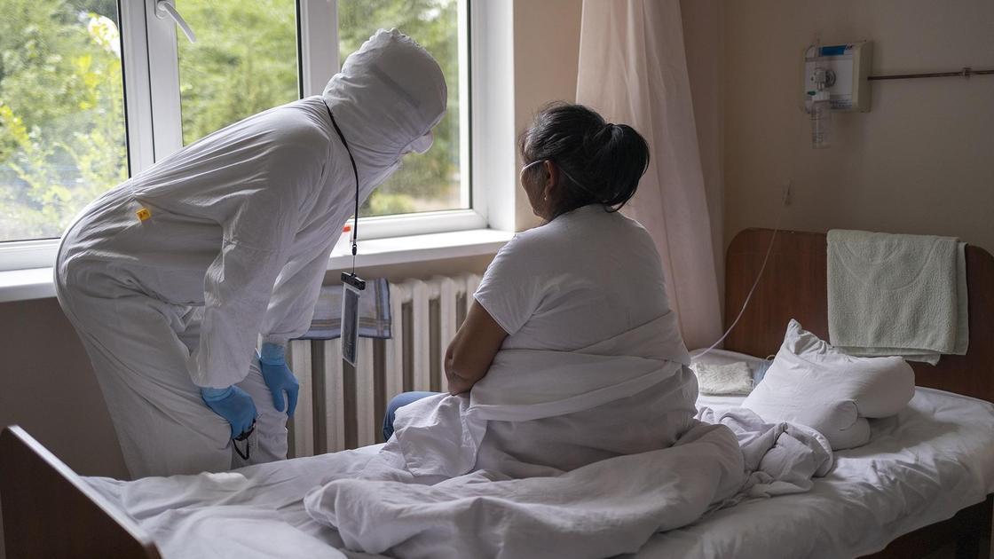врачи в больничной палате стоит возле пациентки