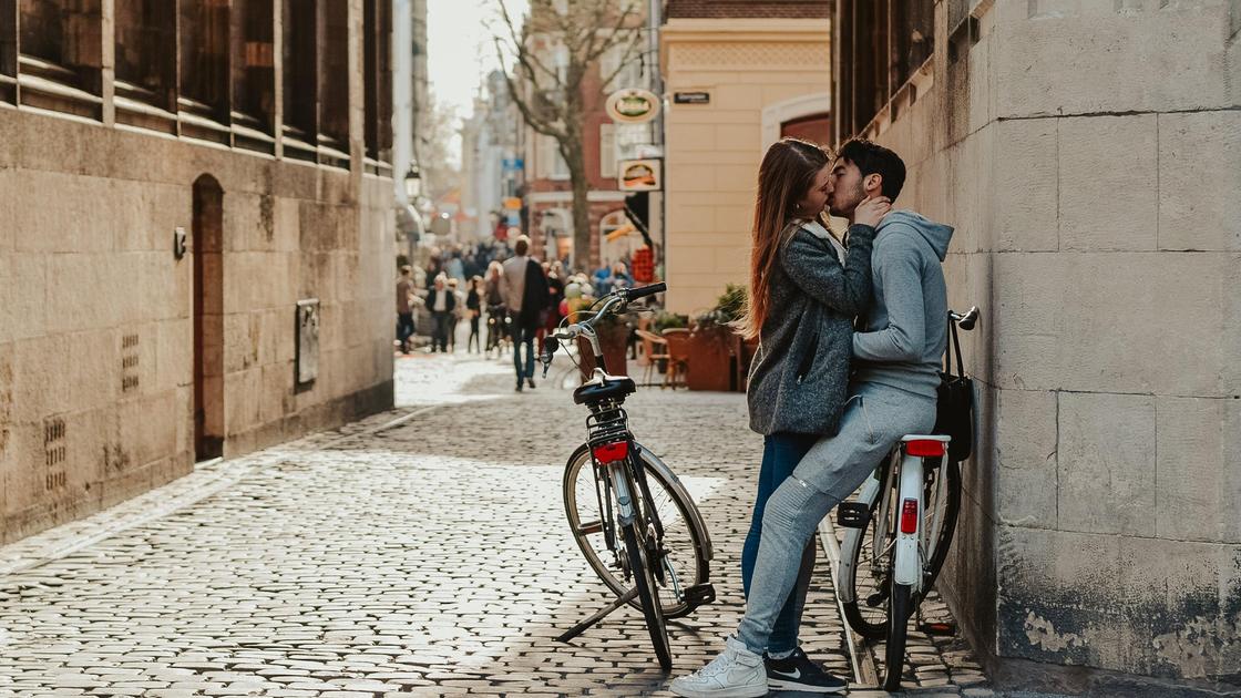 Парень и девушка целуются на улице рядом