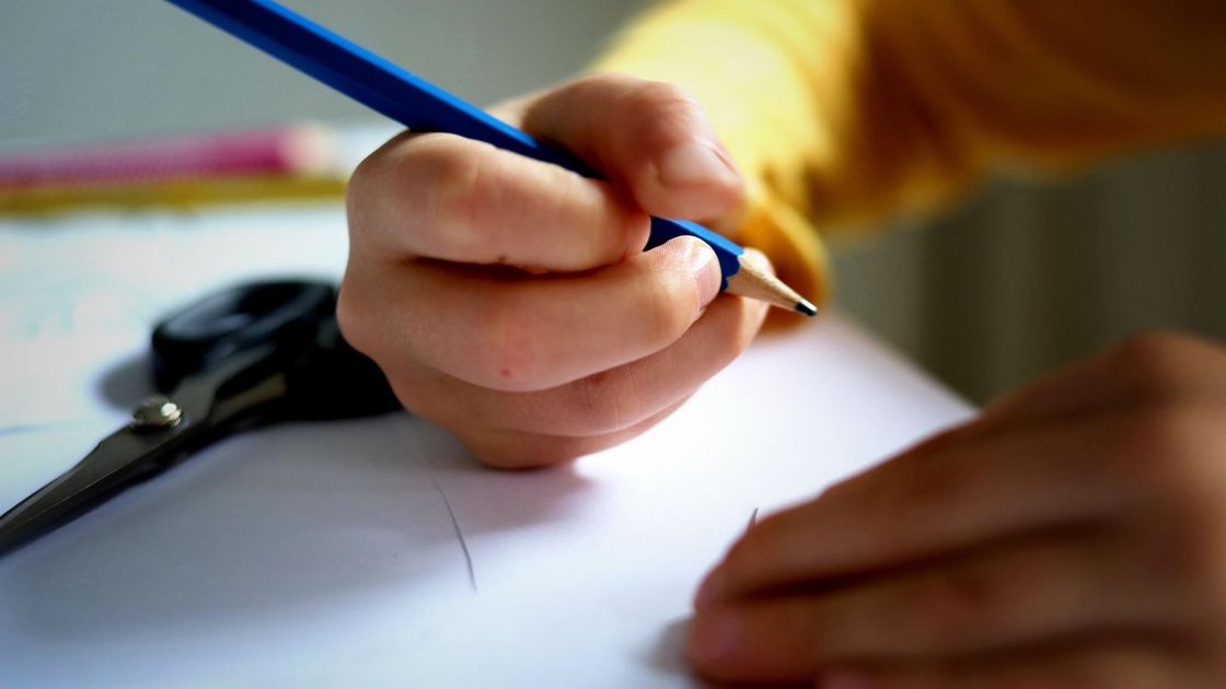 Ребенок держит карандаш в руке