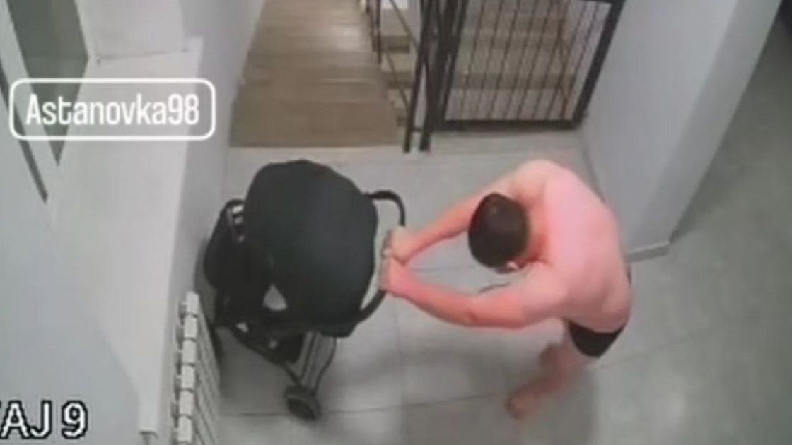 Мужчина с коляской в подъезде