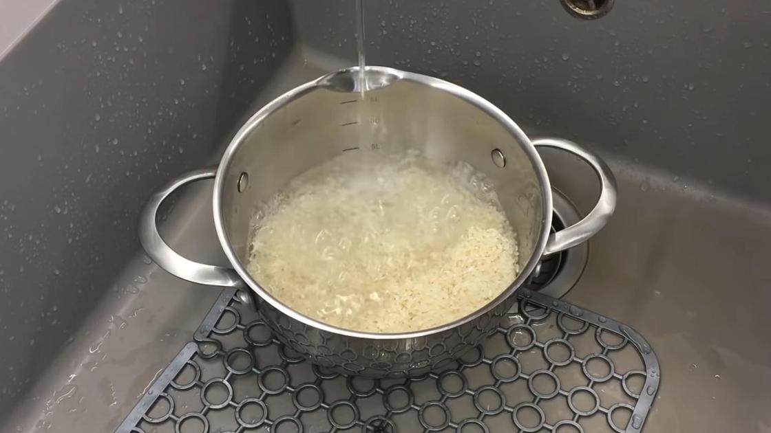 Промывка риса в кастрюле под проточной водой