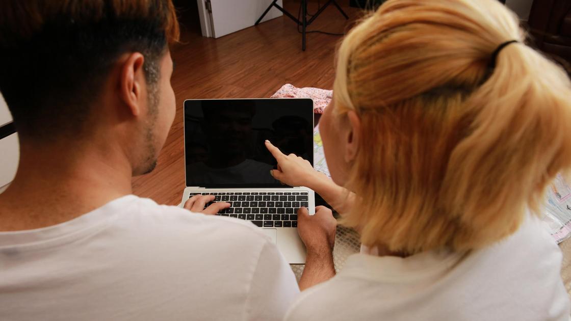 Мужчина и женщина судят перед ноутбуком