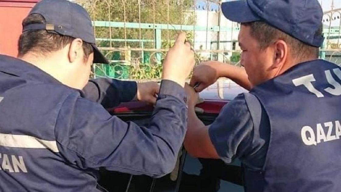 Спасатели вскрывают машину в Атырау