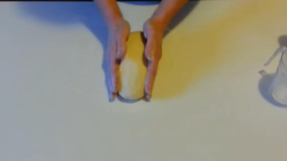 Вымешивание теста руками на поверхности стола