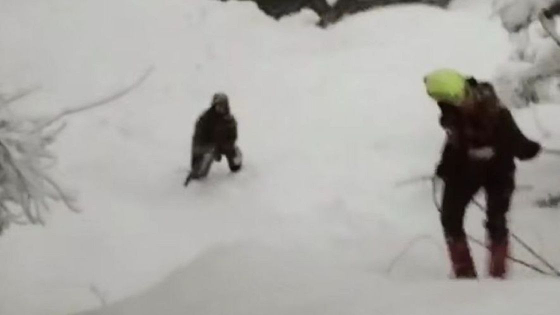 Спасатель спускается в овраг к туристу