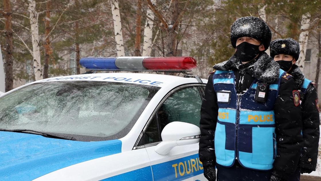 Тәртіп сақшысы қызметтік көлігінің жанында Тәртіп сақшысы қызметтік көлігінің жанында